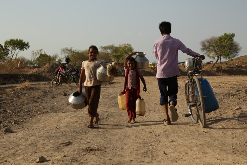 Two children are carrying water